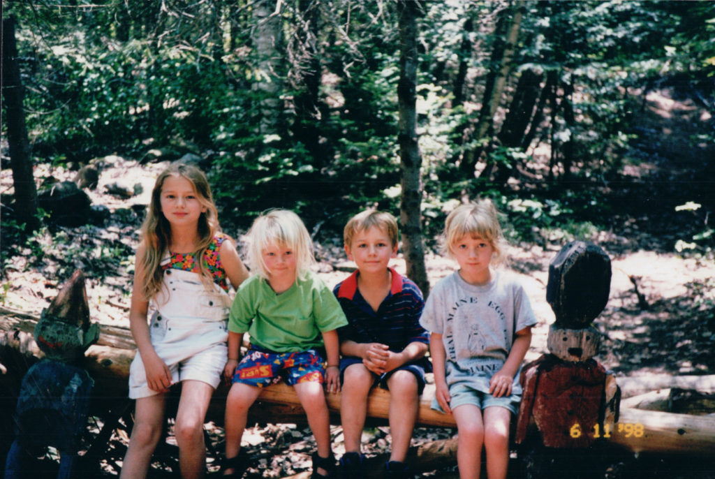 4 children sitting in forest in Maine