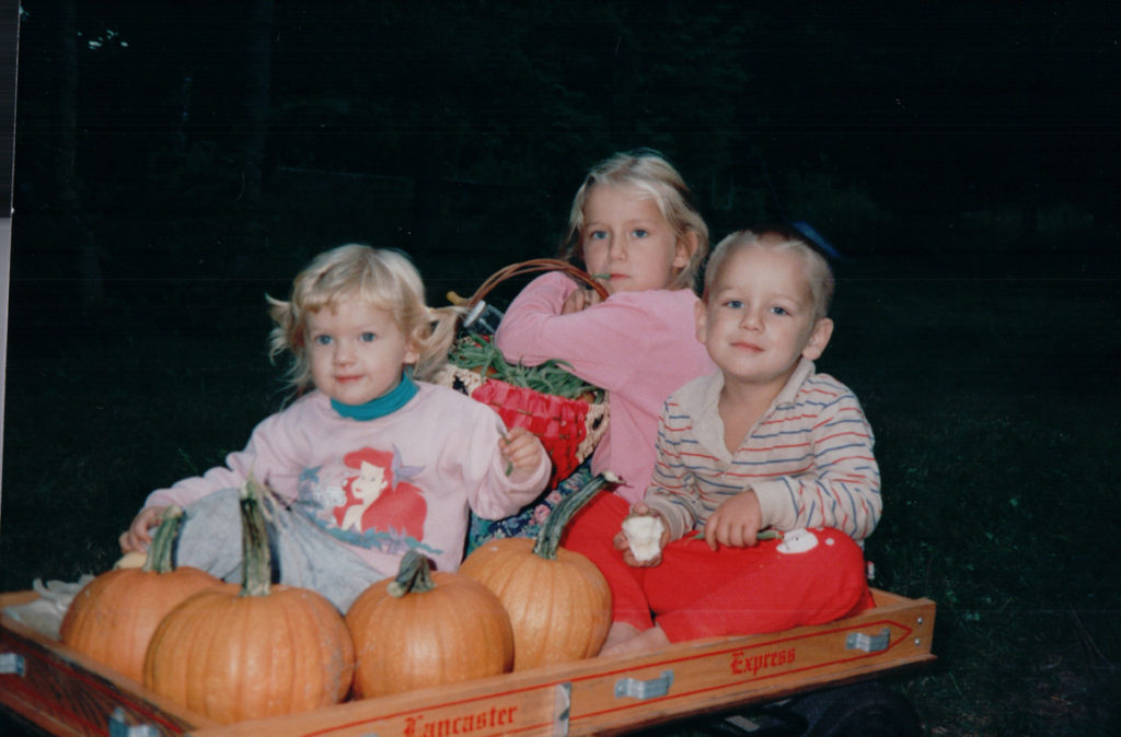 children in wagon with pumpkins